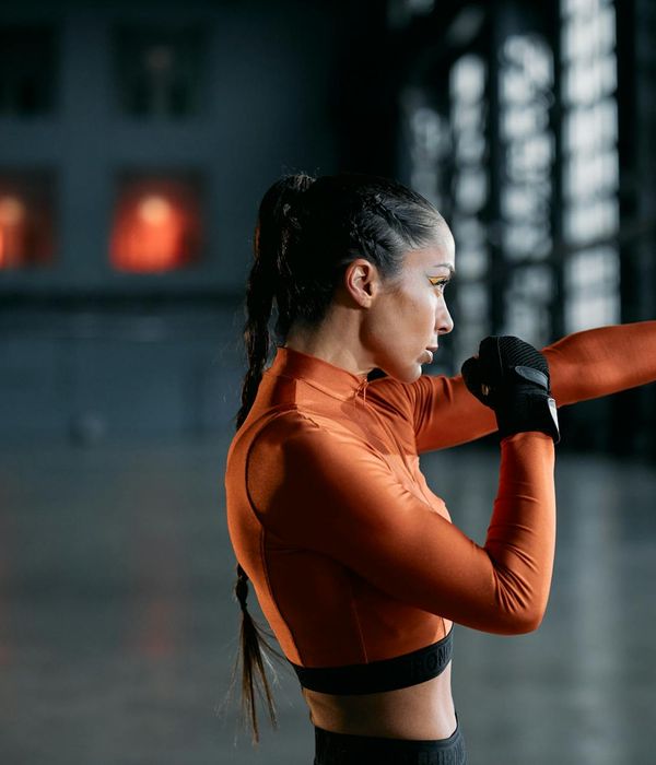 Woman performing a gentle cardio exercise in a calm, well-lit studio.